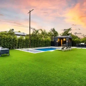 Beautiful backyard with lush green new lawn and swimming pool area showing the final result and cost for a new lawn installation.